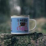 Blue enamelware coffee mug with “I Need Coffee Now” text and cute smiling coffee cup design for caffeine lovers